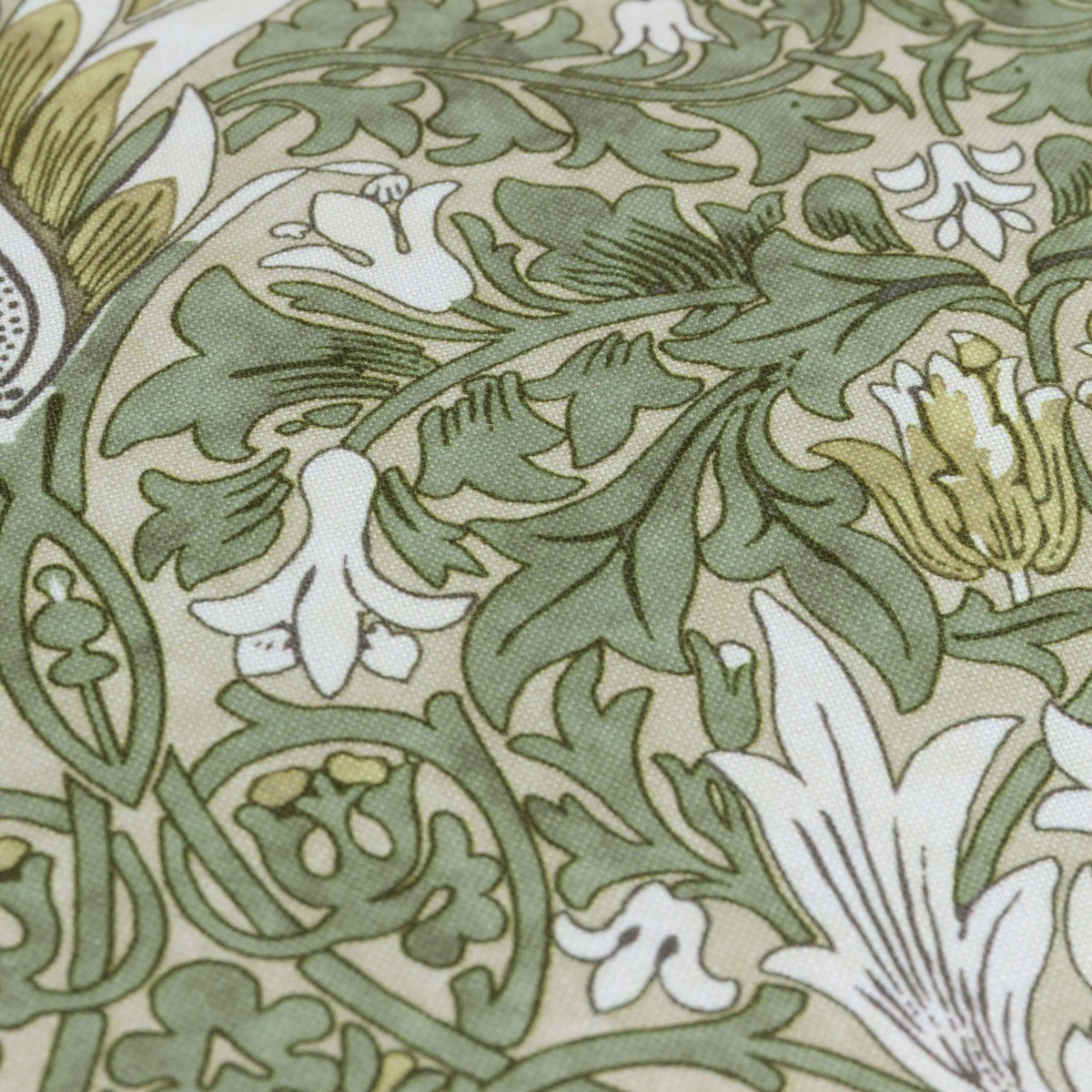 Close-up of the Snakeshead Floral polyester cushion in Sunflower/Stone, showing the mirrored botanical print in green, gold and cream on a stone fabric ground.
