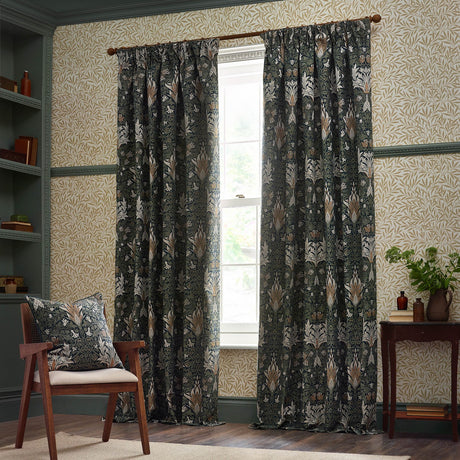Snakeshead Jacquard Chenille pencil pleat curtains in Indigo/Leaf, floral patterned fabric hung at a study window with matching cushion on a nearby chair.