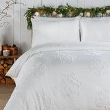 White Snow Crystal duvet cover set with tufted snowflake pattern shown on a bed with matching pillowcases in a bedroom styled for Christmas.