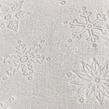 Close-up of the Snowflakes Polyester Faux Fur Cushion in grey, showing snowflake and star motifs textured into the soft pile fabric.