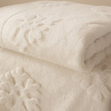 Snowflakes Faux Fur Polyester Velvet Throw in snow white, folded to show a deep, dense pile with raised snowflake motifs textured into the surface.