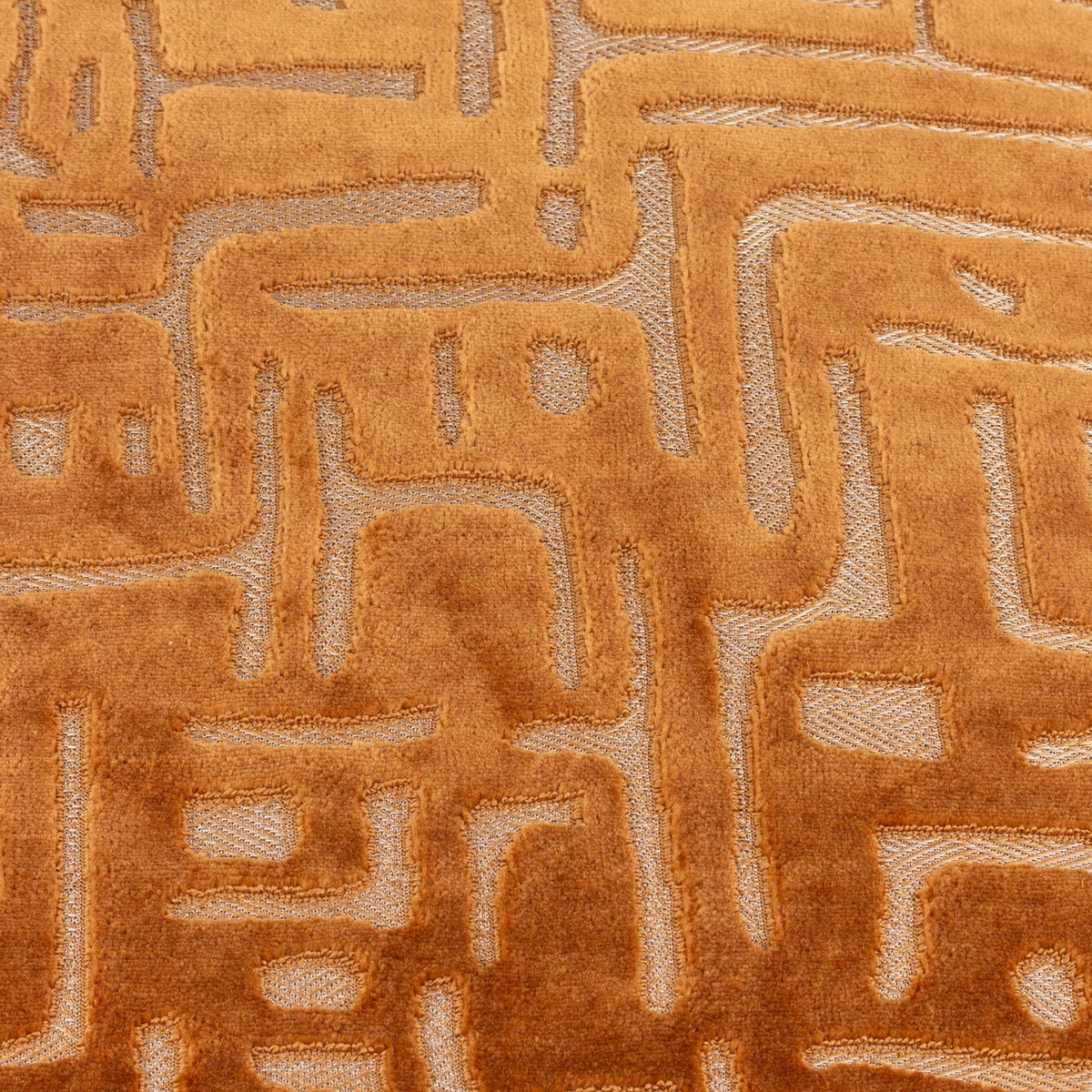 Close-up of the Soren Abstract Velvet Cushion in copper, showing a maze-like geometric pattern in cut velvet pile with contrasting matte and sheen textures.