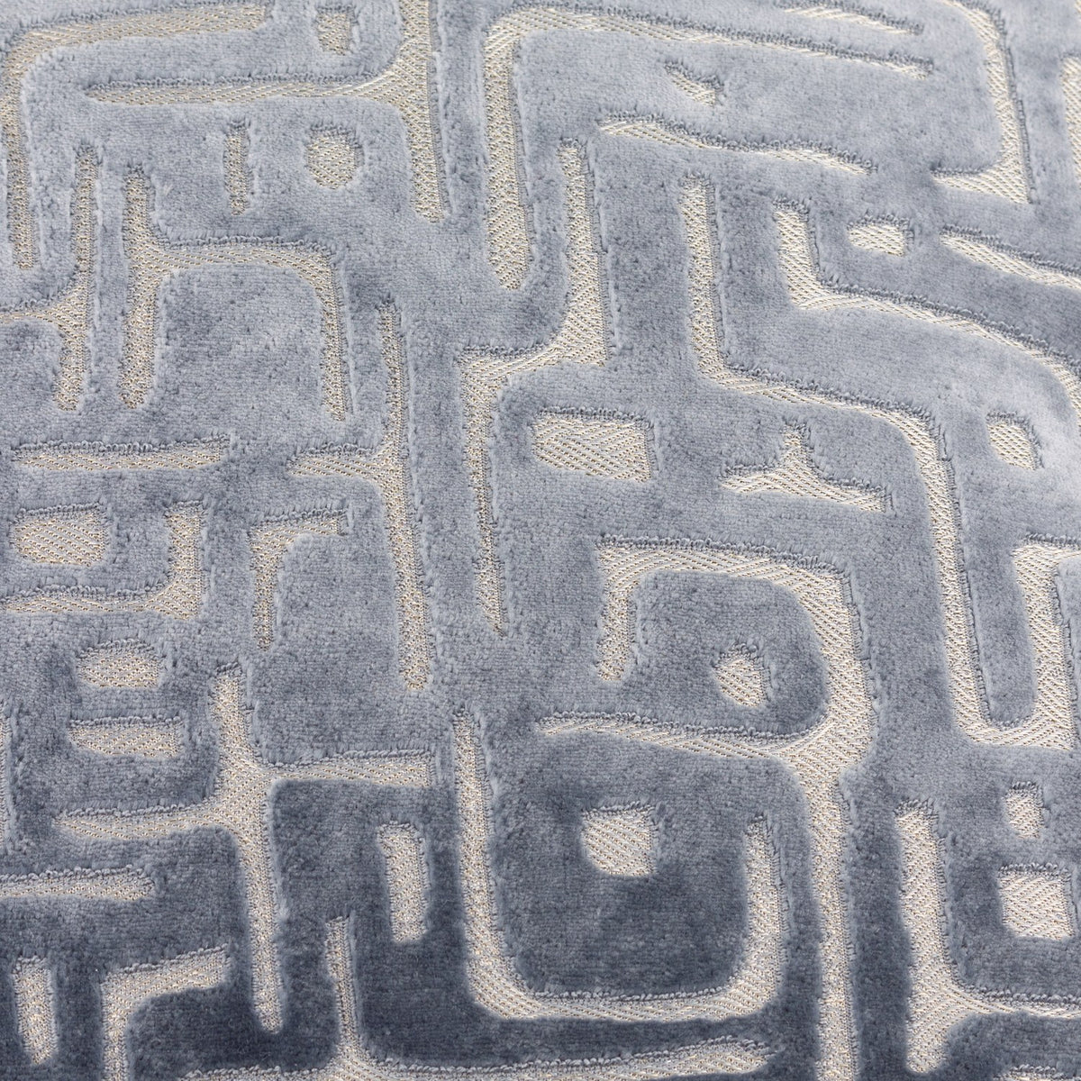 Close-up of the Soren Abstract Velvet Cushion in slate blue, showing raised cut-velvet geometric lines against a flatter woven ground.