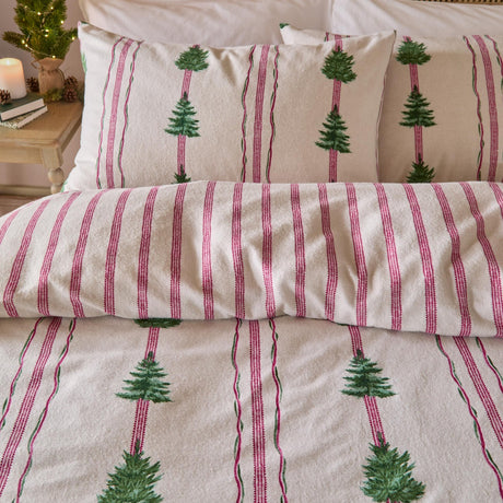 Spruce Stripes Cotton Reversible Duvet Cover Set in Oat on a bed, showing brushed cotton fabric with green Christmas trees between pink and green vertical stripes, with matching pillowcases.