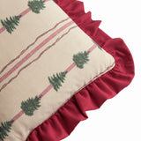 Spruce Stripes linen-cotton cushion corner detail showing beige fabric with green fir tree print, red and green stripes, and a gathered dark red ruffle edge.