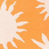 Close-up of the Summer Solstice Reversible Abstract Rug in Sunrise Yellow, showing a woven sun-ray pattern in cream against a warm orange background.
