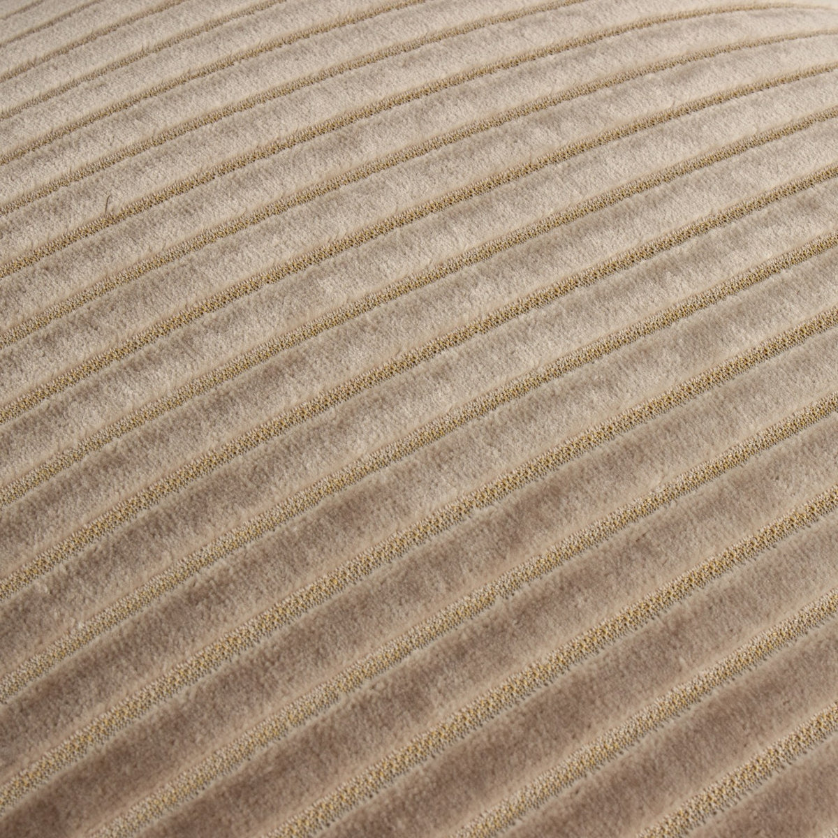 Close-up of the Savoy Stripe cushion in mink, showing diagonal cut-pile velvet ridges in beige with a subtle sheen against recessed woven channels.