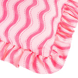 Close-up of the Summer Solstice Wiggly Stripe polyester cushion in hot pink, showing wavy vertical stripes with dotted stitch detail and a gathered ruffle trim edge.