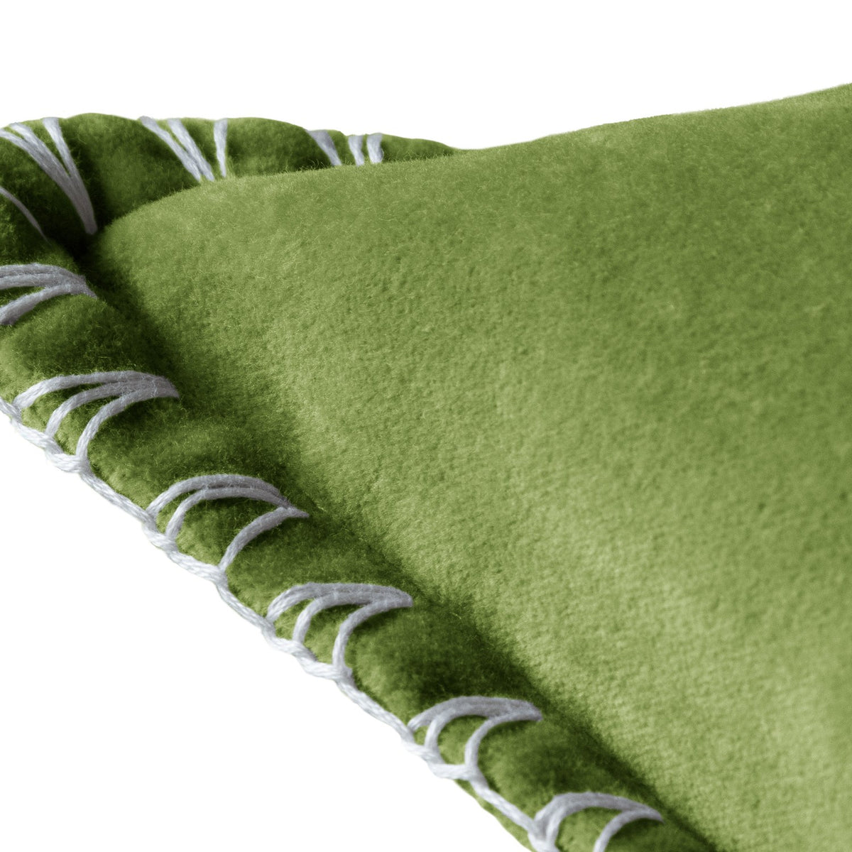 Close-up of the Stitch Plain Velvet Cushion in grass green, showing dense velvet pile and a pale contrast blanket-stitch edge, on a white background.