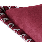 Close-up of the Stitch Plain Velvet Cushion in pomegranate red velvet, showing the smooth fabric texture and hand-worked blanket stitch edge in pale grey thread against a white background.