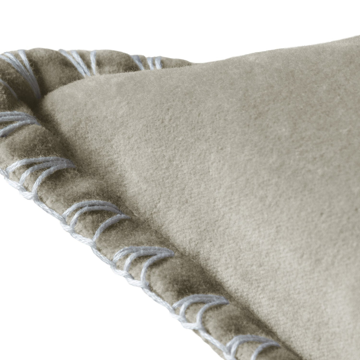 Close-up of the Stitch Plain Velvet Cushion in Quartz, showing grey-beige velvet fabric with a pale cream blanket stitch trim along the folded edge.