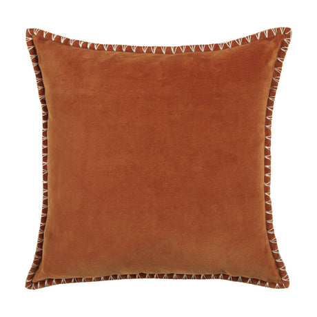 Square velvet cushion in warm sunset orange with a hand-worked blanket stitch in pale contrast thread along the edges, shown on a plain white background.