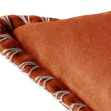 Close-up of the Stitch Plain Velvet Cushion in Sunset, showing rust-orange velvet fabric with a hand-worked pale grey blanket stitch along the folded edge.