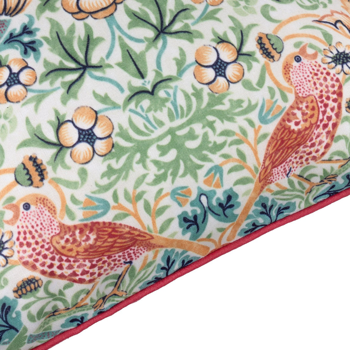 Strawberry Thief Floral Polyester Cushion corner detail, showing coral birds among strawberries and foliage on a pale ground with a coral piped edge trim.