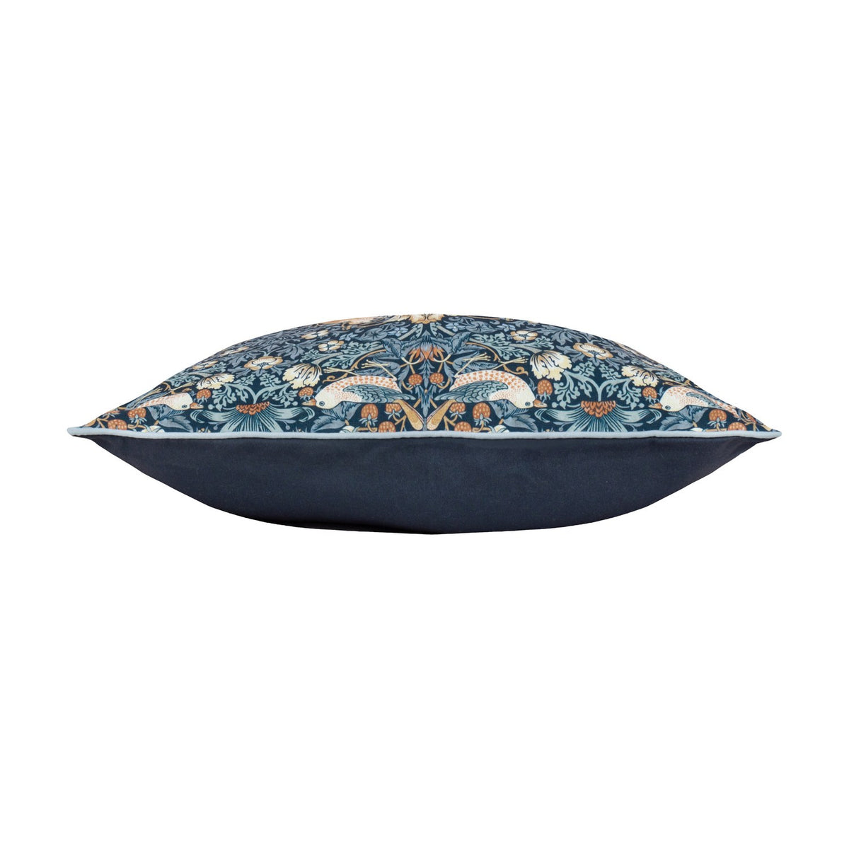 Side view of the Strawberry Thief Floral Polyester Cushion in indigo, showing the William Morris bird and strawberry print with pale piping against a plain solid indigo reverse, on a white background.