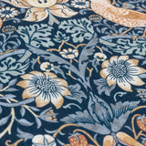 Close-up of the Strawberry Thief Floral Polyester Cushion in indigo, showing William Morris's dense pattern of birds, strawberries and flowers in amber, cream and pale blue on a deep indigo ground.