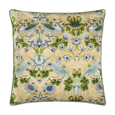 Square Strawberry Thief Floral Polyester Cushion in Sunflower yellow, with William Morris bird and berry pattern in blue and green, green piped edge, on a white background.