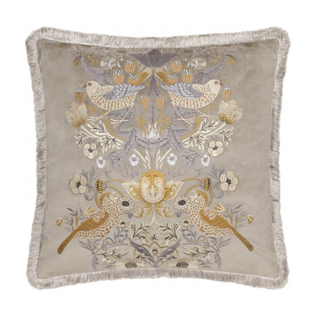 Square biscuit-beige velvet cushion with Strawberry Thief bird and foliage embroidery in gold, amber and grey tones, finished with matching fringe trim, on a white background.