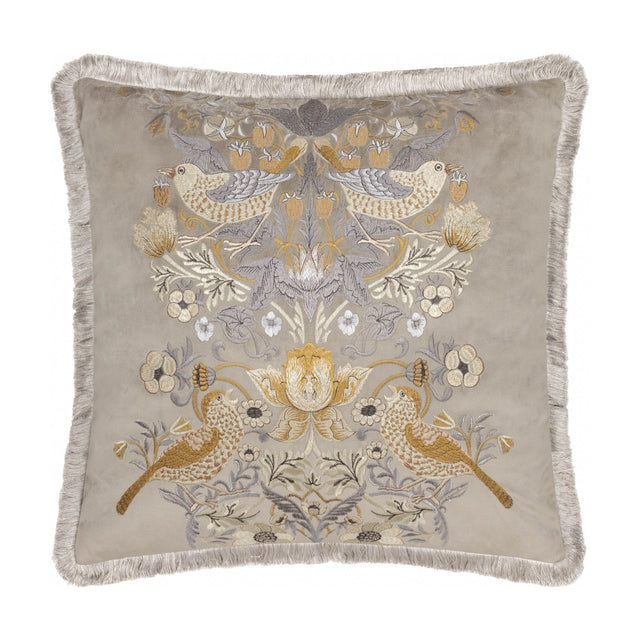 Square biscuit-beige velvet cushion with Strawberry Thief bird and foliage embroidery in gold, amber and grey tones, finished with matching fringe trim, on a white background.