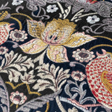 Close-up of the Strawberry Thief Jacquard Velvet Cushion in indigo, showing embroidered birds, strawberries and a golden central bloom on deep blue velvet with cream, gold, rust and pink detailing.