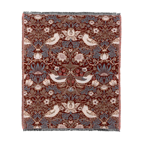 Strawberry Thief Jacquard Cotton Throw in berry-red, woven with bird, floral and strawberry motifs in blue, cream and brown, fringed edges, shown on a plain white background.