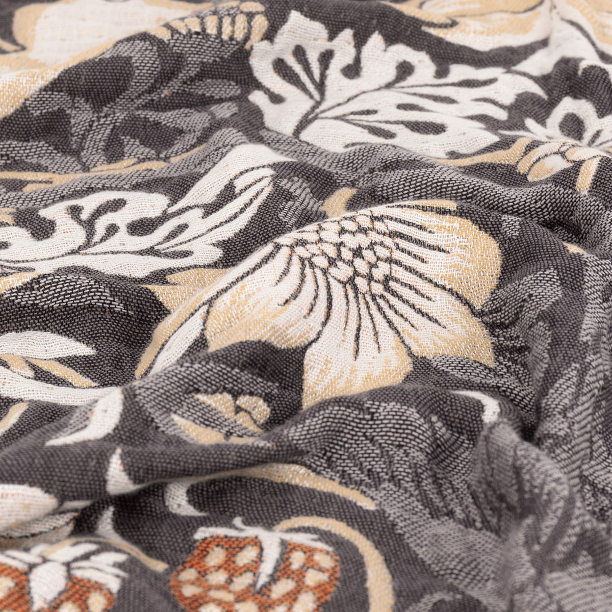 Strawberry Thief Jacquard Cotton Throw in Biscuit, close-up of woven charcoal, cream and gold bird and floral pattern showing the fabric's textured jacquard weave.