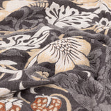 Strawberry Thief Jacquard Cotton Throw in Biscuit, close-up of woven charcoal, cream and gold bird and floral pattern showing the fabric's textured jacquard weave.