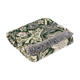 Folded Strawberry Thief jacquard cotton throw in forest green with cream bird and floral pattern and grey fringed edge, shown on a white background.
