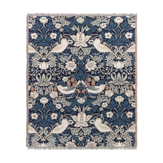 Strawberry Thief Jacquard Cotton Throw in indigo, woven with birds, strawberries and trailing floral motifs in cream, rust and blue tones, with fringed edges on a white background.