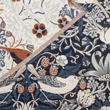 Strawberry Thief Jacquard Cotton Throw in indigo, close-up of reversible woven fabric showing birds, strawberries and florals in cream, rust and blue tones with fringed edge trim.