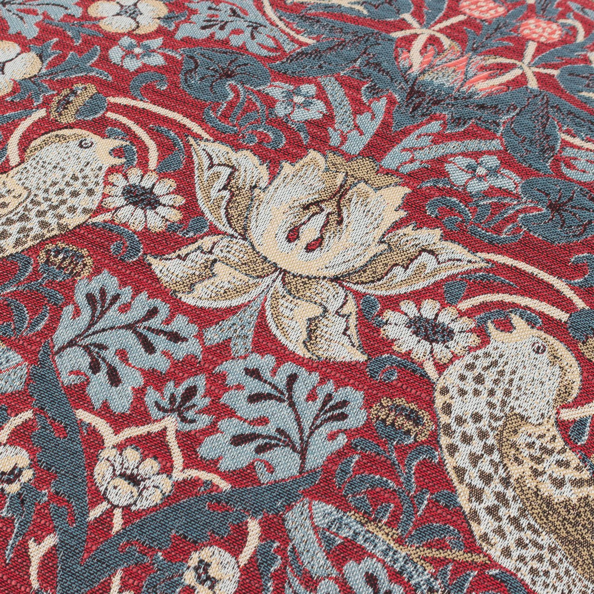 Close-up of the Strawberry Thief Jacquard Velvet Cushion in berry red, showing woven thrushes, tulips and scrolling foliage in slate blue and cream tones.