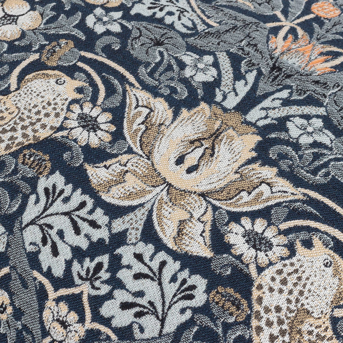 Close-up of the Strawberry Thief Jacquard Velvet Cushion in indigo, showing woven birds, strawberries and scrolling foliage in beige, grey and orange tones.