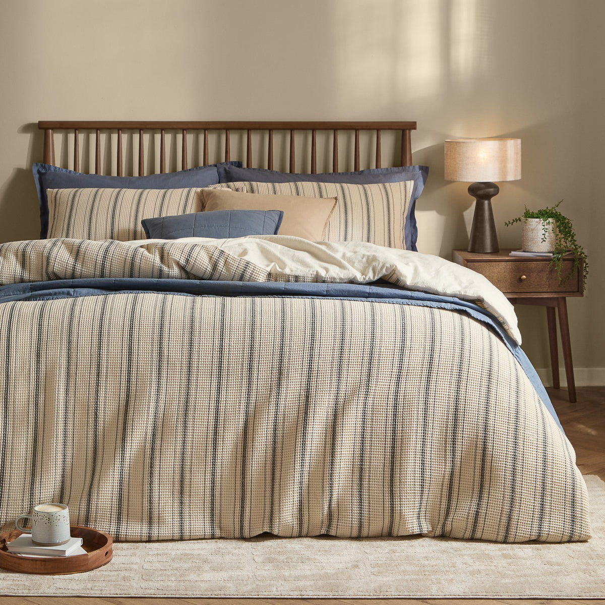 Selby waffle cotton striped duvet cover set in coal and natural on a bed with matching pillowcases, styled with blue accent bedding in a bedroom setting.