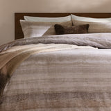 Swift Cotton Striped Duvet Cover Set in Natural, brushed cotton bedding with muted beige stripes, styled on a bed with a wooden headboard and brown accent cushions.