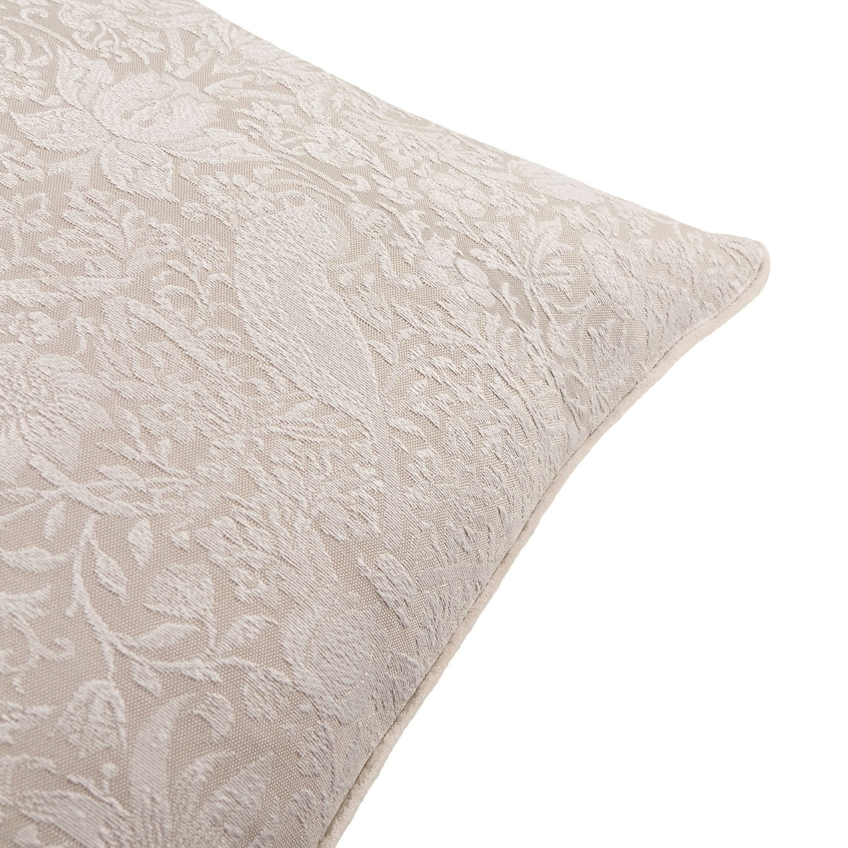 Close-up of the Strawberry Thief Jacquard Linen Cushion in linen, showing a woven off-white floral and bird pattern with piped edge corner detail on a plain white background.