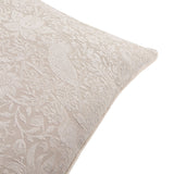 Close-up of the Strawberry Thief Jacquard Linen Cushion in linen, showing a woven off-white floral and bird pattern with piped edge corner detail on a plain white background.