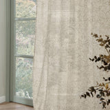 Strawberry Thief Floral Linen Curtain Panel in cream, semi-sheer fabric with tonal floral print, shown hanging beside a window overlooking greenery.