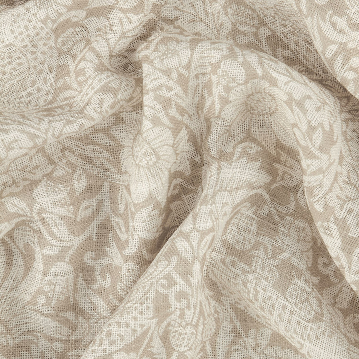 Strawberry Thief Floral Linen Curtain Panel draped in soft folds, showing a cream and sand tonal floral scroll pattern on semi-sheer open-weave voile fabric.
