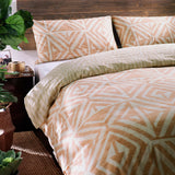 Tanza Geometric Animal Duvet Cover Set in terracotta and cream, styled on a bed with matching pillowcases in a rustic bedroom setting.