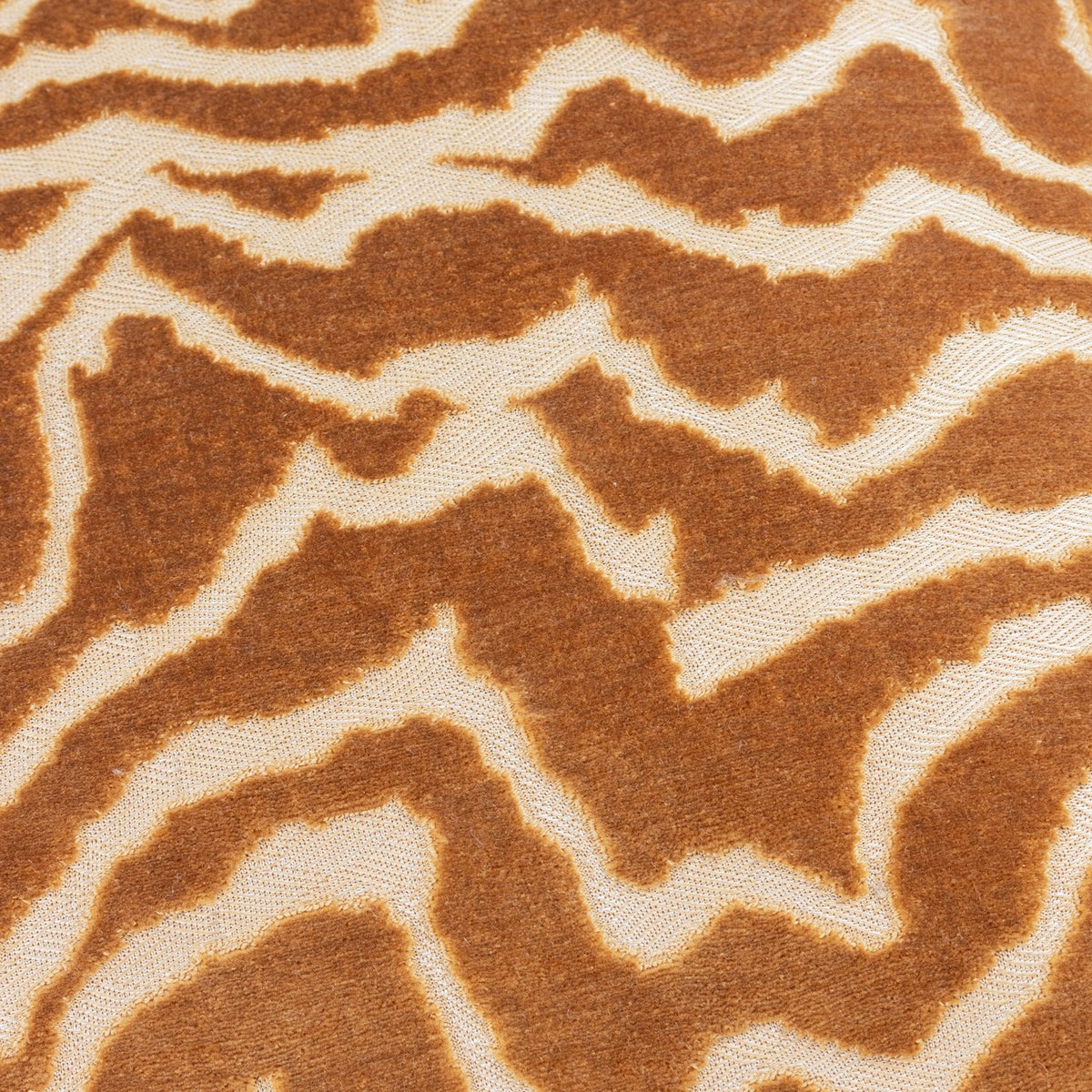 Close-up of the Tierra Abstract Velvet Cushion in bronze, showing a marbled cut-velvet pattern in warm russet brown against a paler woven ground.