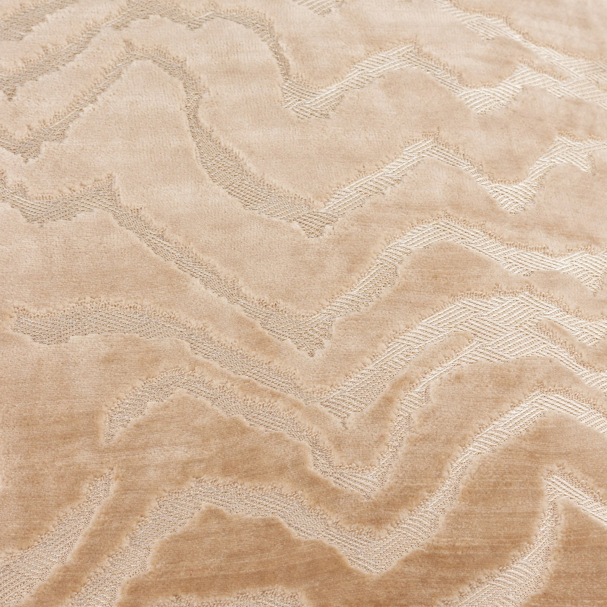 Close-up of the Tierra Abstract Velvet Cushion in taupe, showing a cut-velvet mountain-like pattern with raised pile catching light against a plain velvet ground.