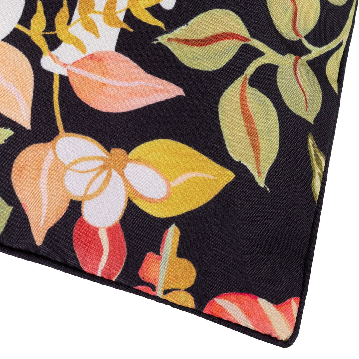 Close-up of the Tropical Bloom Lost reversible polyester cushion corner in black, showing coral, pink, olive and mustard leaf and floral print with piped edge finish.