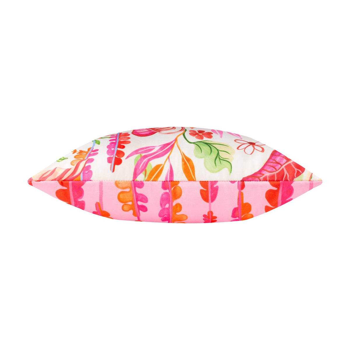Side view of the Tropical Bloom reversible polyester cushion, showing cream floral print on one edge and pink leaf-stripe pattern on the other, set against a white background.