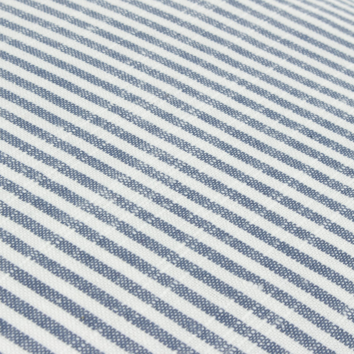 Close-up of the Truro Stripe Reversible Cotton Cushion in Skyline, showing narrow yarn-dyed blue and white stripes on a slub-textured cotton weave.