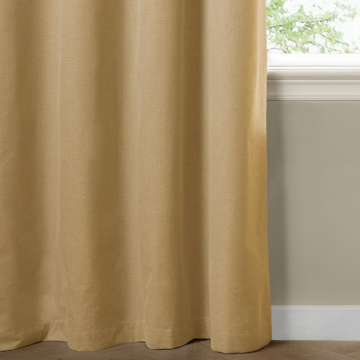 Yellow blackout eyelet curtain in plain woven polyester fabric, shown floor-length beside a window in a room with pale green walls and wood flooring.