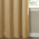 Yellow blackout eyelet curtain in plain woven polyester fabric, shown floor-length beside a window in a room with pale green walls and wood flooring.
