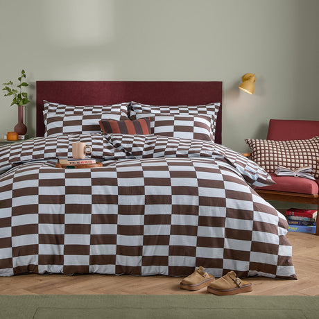 The Ultimate Checkerboard Check Duvet Cover Set in Blueberry Muffin styled on a bed with matching pillowcases, brown and white check pattern, in a bedroom setting with a red headboard.