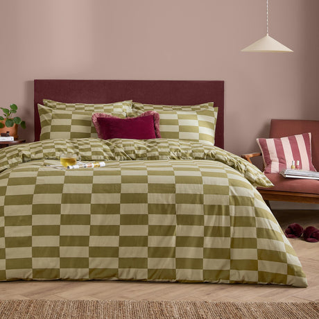 The Ultimate Checkerboard Check Duvet Cover Set in Green Tea, a reversible cotton-blend duvet with oblong check print, styled on a bed with maroon headboard and pink cushion.