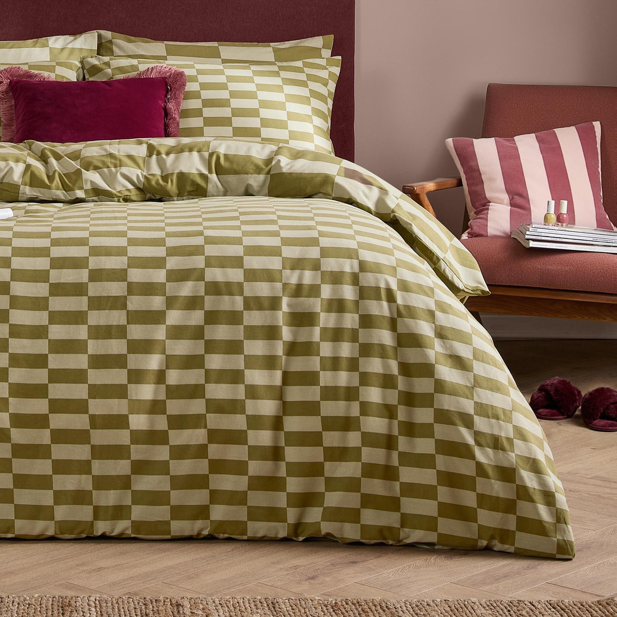 The Ultimate Checkerboard Check Duvet Cover Set in Green Tea styled on a bed with matching pillowcases, shown in a bedroom with pink walls and a striped cushion nearby.
