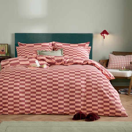 The Ultimate Checkerboard Duvet Cover Set in Raspberry Smoothie, a pink and burgundy checkerboard cotton-blend bedding set styled on a bed with matching pillowcases and cushions.